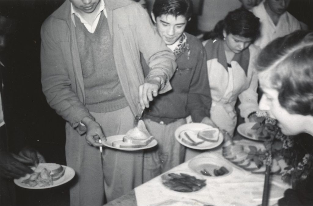 Attendees getting food from a banquet table at a reception at Hull-House