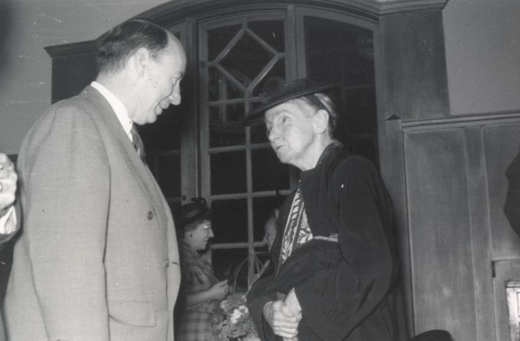 Illinois governor Adlai Stevenson II and Hull-House resident Edith Abbott talking at a reception at Hull-House
