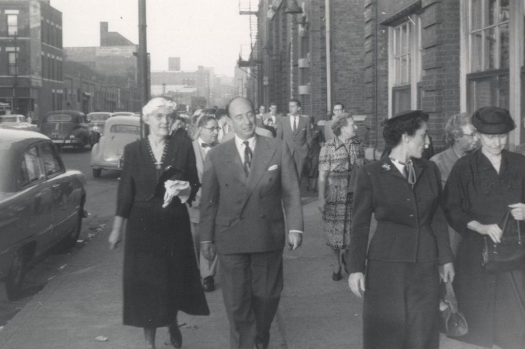 Illinois governor Adlai Stevenson II walking with Hull-House board president Alma Petersen and others on Polk St. outside Hull-House