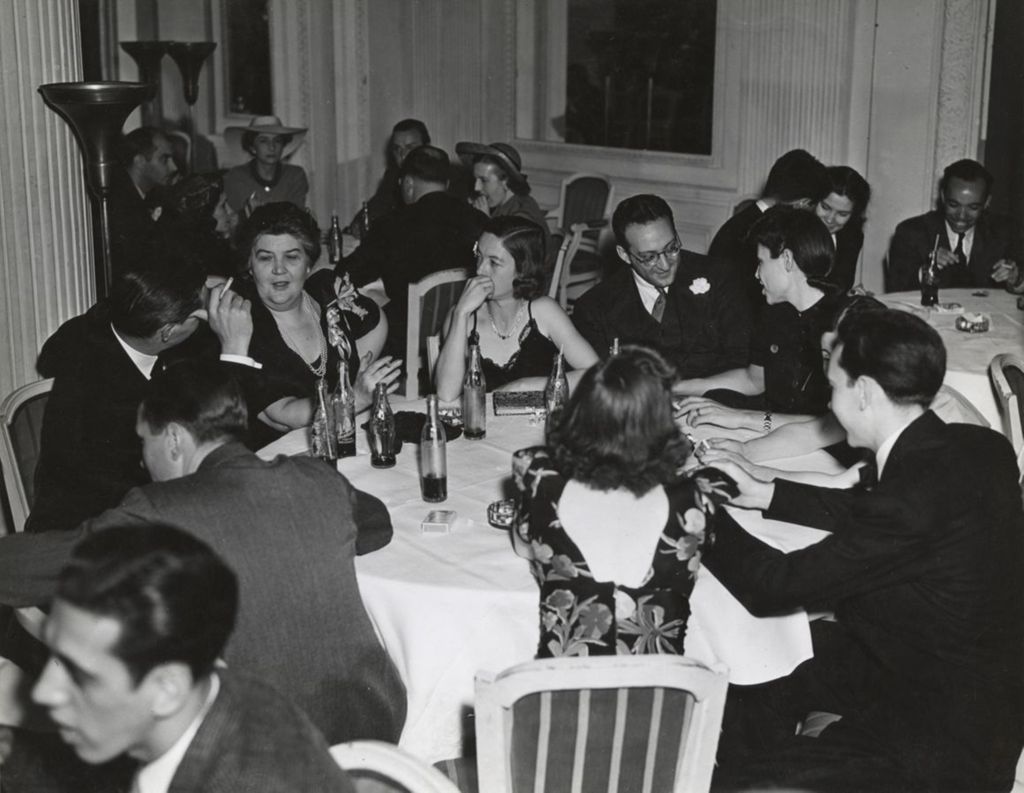 Hull-House director Charlotte Carr and other attendees at the 1941 Lilac Ball at the Stevens Hotel sitting around three tables