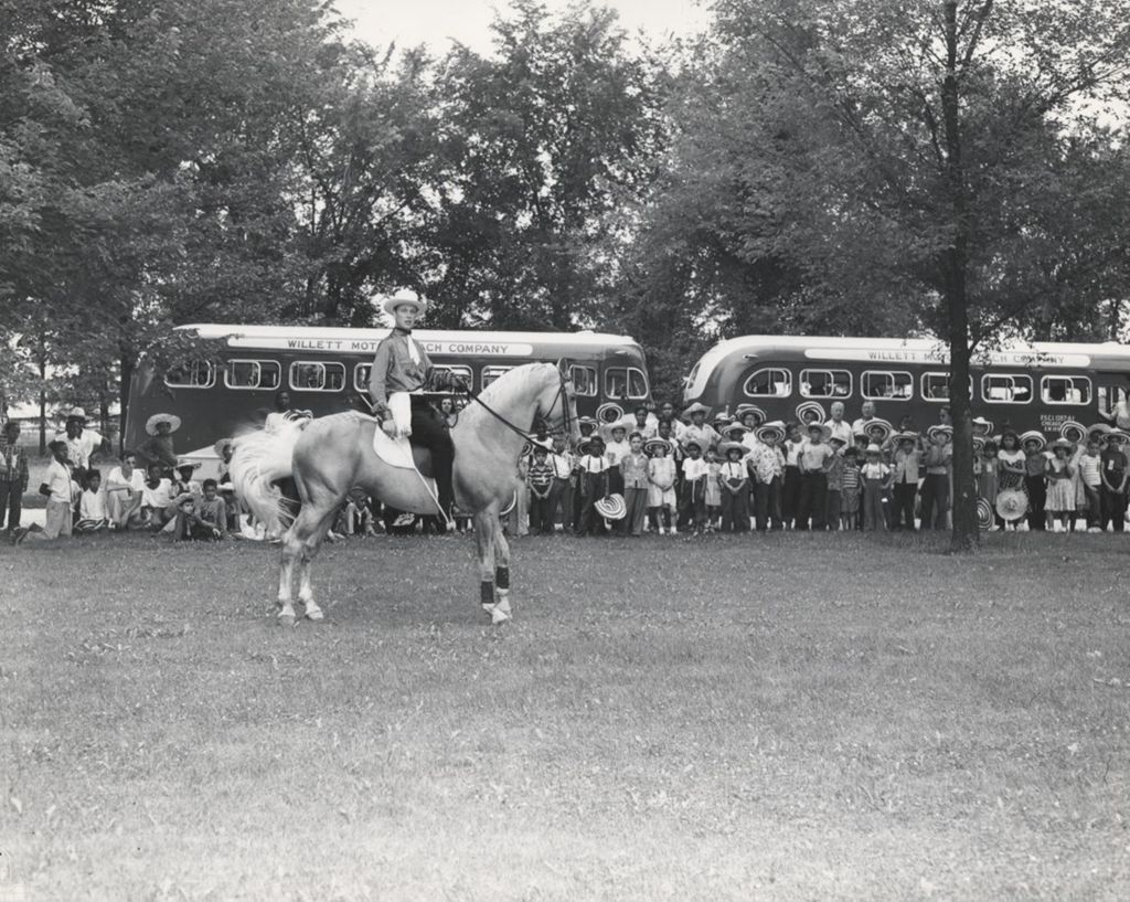 Dozens of children from Hull-House watching a man on a horse at Hawthorn-Mellody Farms