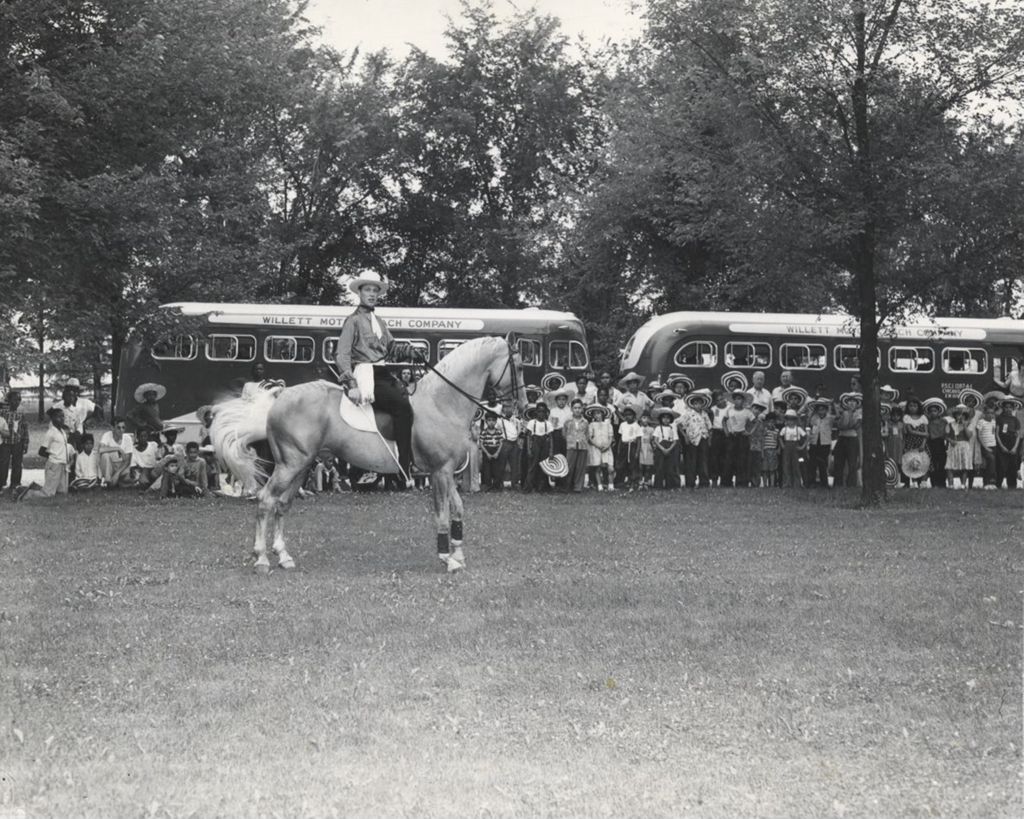 Dozens of children from Hull-House watching a man on a horse at Hawthorn-Mellody Farms
