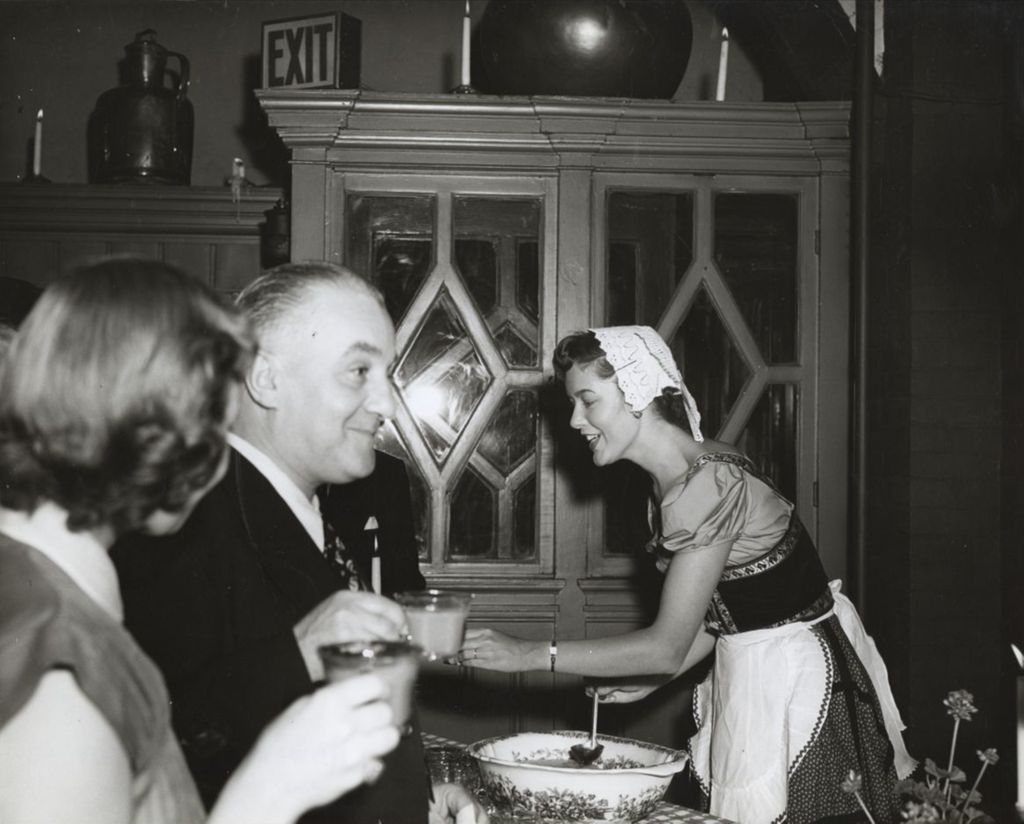 Woman serving punch at an event celebrating the Hull-House 50th Anniversary