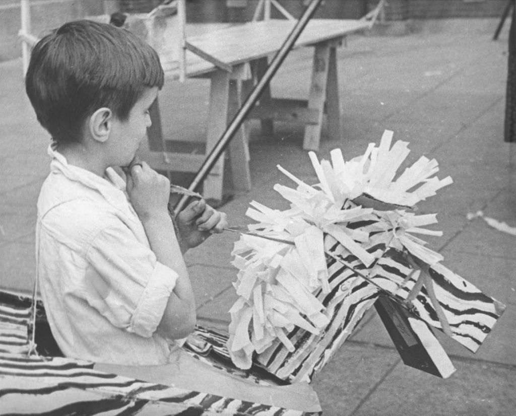 Miniature of Boy wearing a cardboard zebra costume around his waist at the Hull-House 50th Anniversary circus in the Mary Crane Nursery courtyard