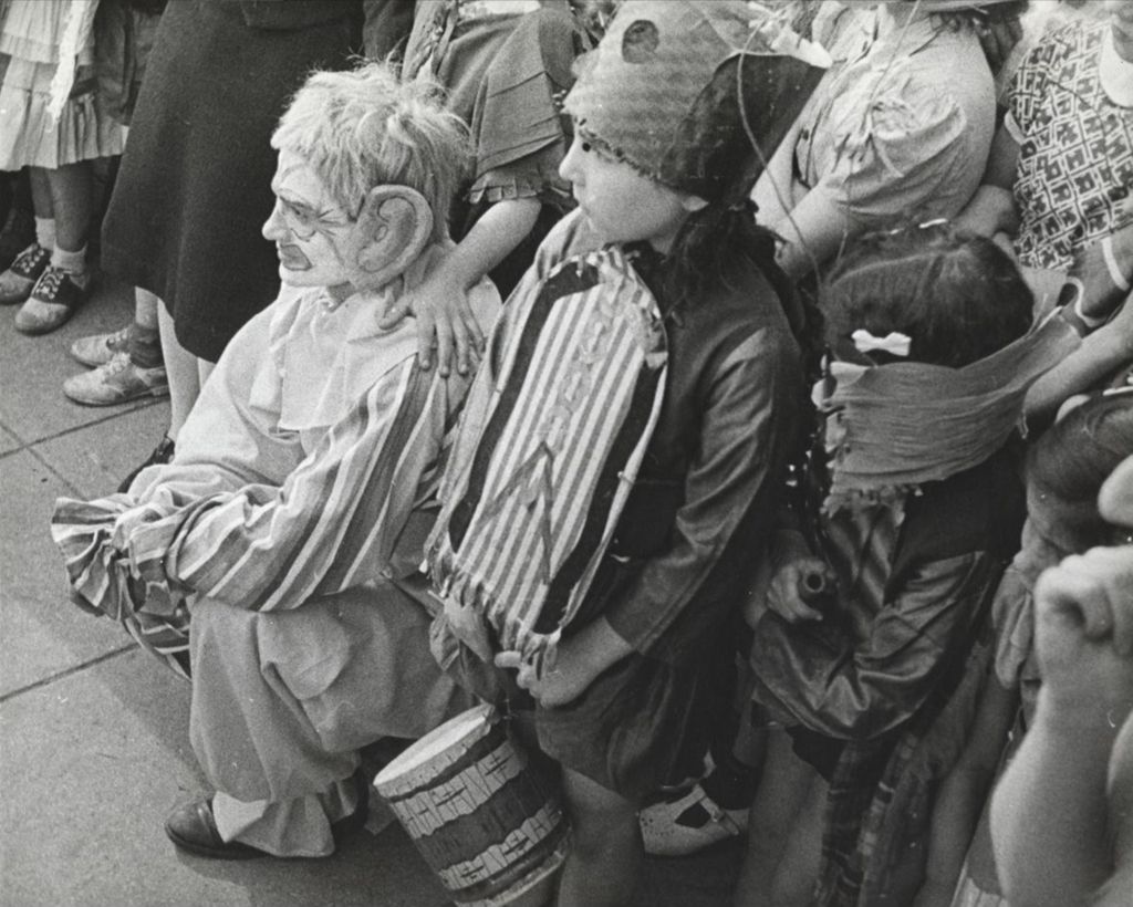 Children in costume watching the Hull-House 50th Anniversary circus in the Mary Crane Nursery courtyard