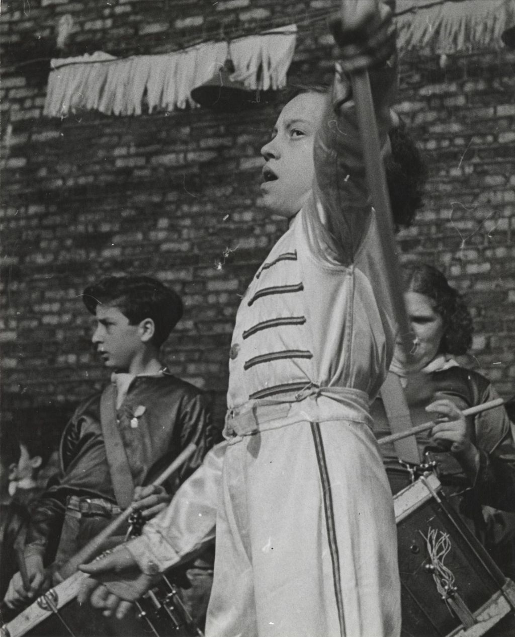 Miniature of Drum major and two drummers performing on stage in the Mary Crane Nursery courtyard as part of Hull-House 50th Anniversary circus show
