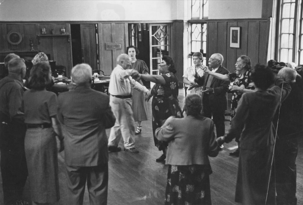 Miniature of A man and woman dancing with a circle of others around them in a Hull-House senior citizens group