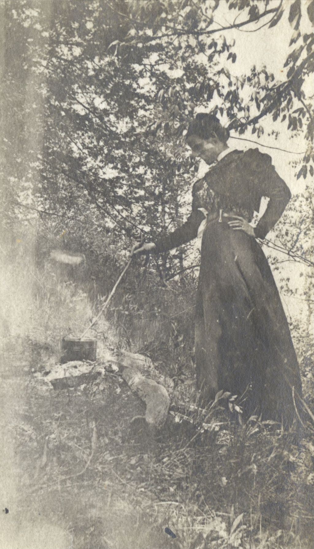 Miniature of Woman standing outdoors, cooking in a tin can