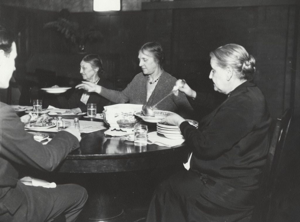 Hull-House co-founder and head resident Jane Addams dining with other residents in the Residents' Dining Hall