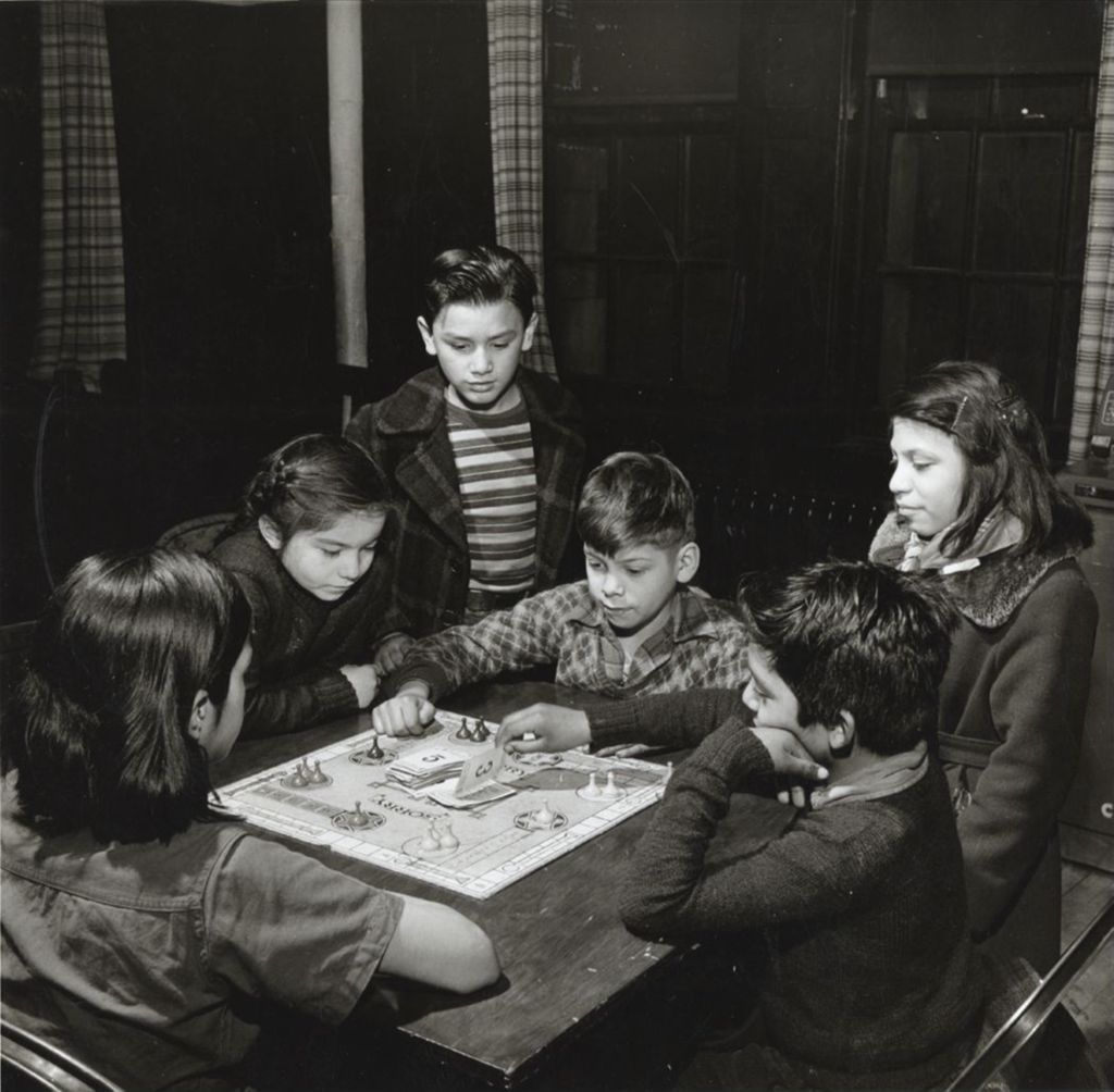 Children around a table at Hull-House playing the board game Sorry!