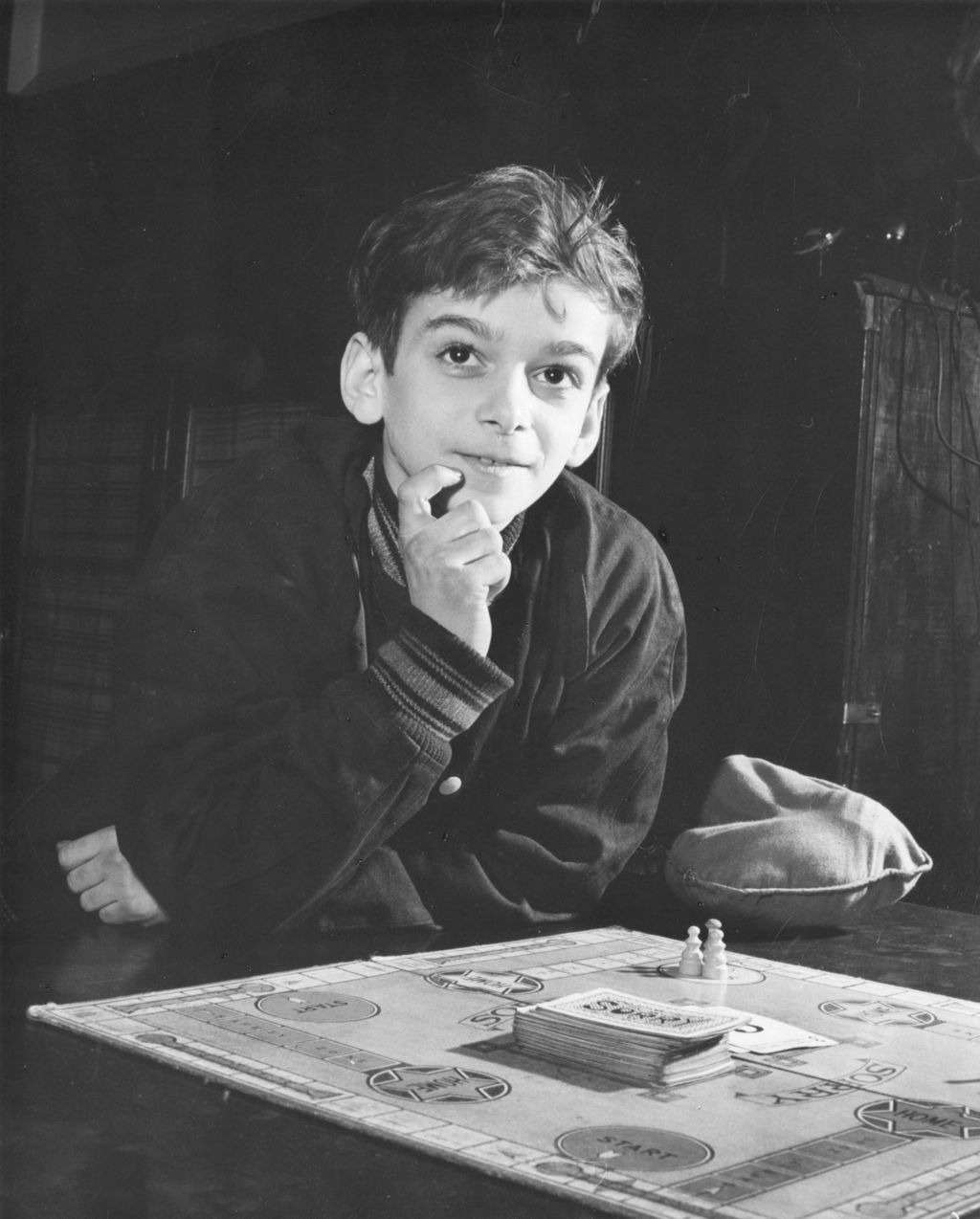 Boy leaning over board game Sorry! at Hull-House
