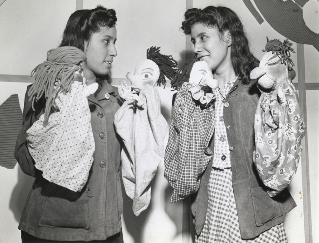 Two girls with puppets on each hand at the Hull-House 1942 Associates Annual Dinner