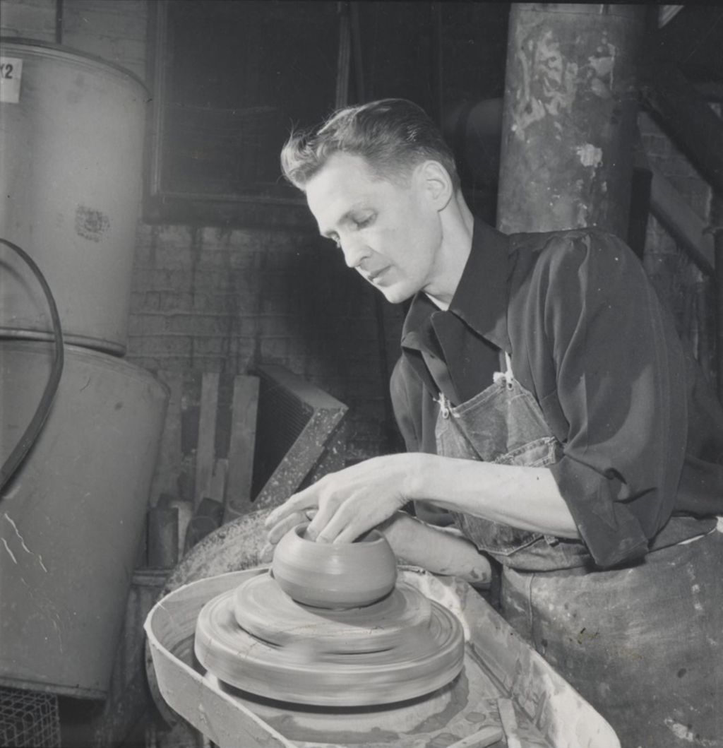 Man sculpting clay pot at a potter's wheel at Hull-House Kilns