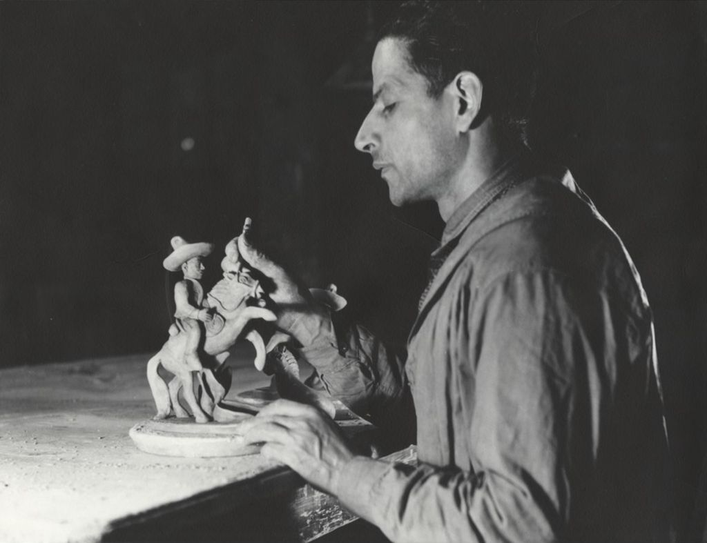 Artist finishing a clay model of a Mexican cowboy on a horse at Hull-House Kilns