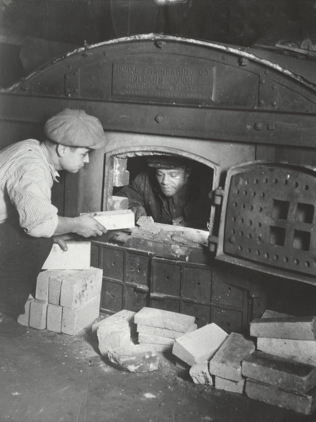 Hull-House Kilns foreman Nick Fosco and another man lining a kiln with bricks
