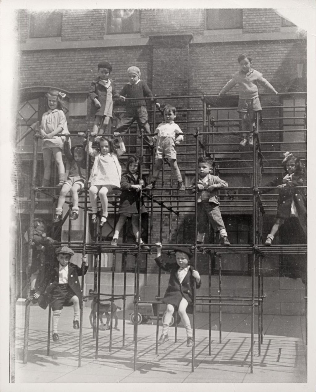 Miniature of Thirteen children playing on the jungle gym in the Mary Crane Nursery courtyard