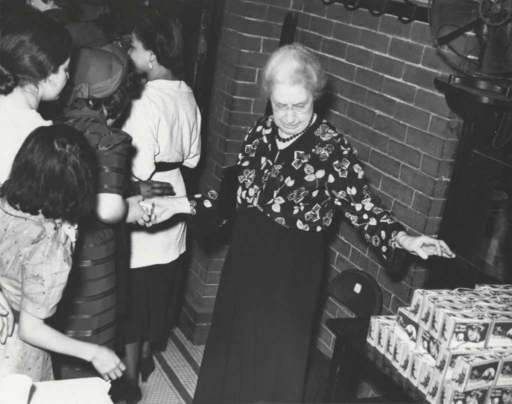 Miniature of Hull-House Music School director Gertrude Smith handing holiday boxes to young people