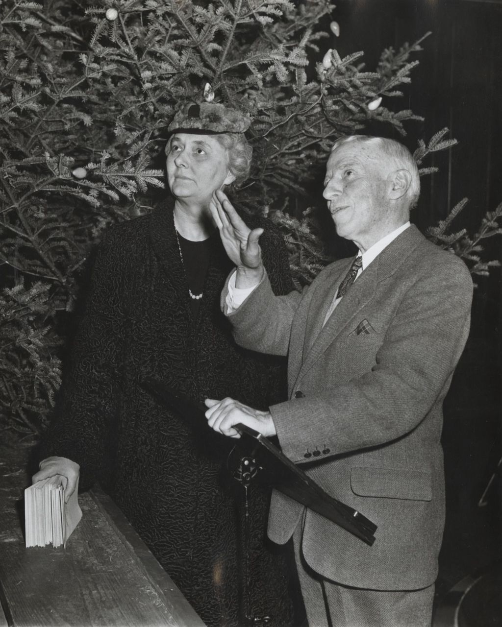 Miniature of Hull-House board president Alma Petersen stands next to man at Hull-House event during Christmas season
