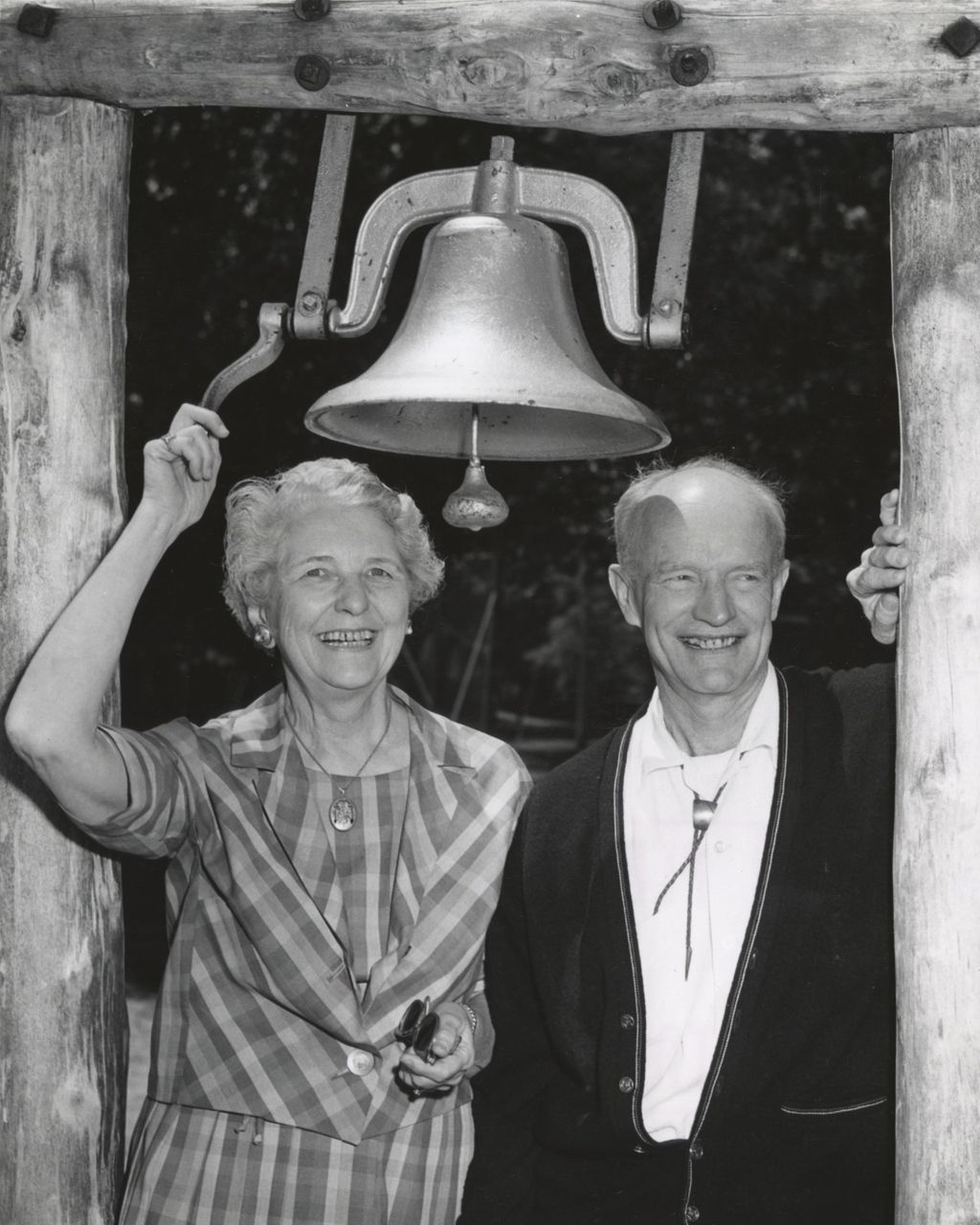 Ada Hicks and Robert Hicks, former co-directors of Bowen Country Club, standing under a bell during Bowen Country Club's 50th Anniversary celebration