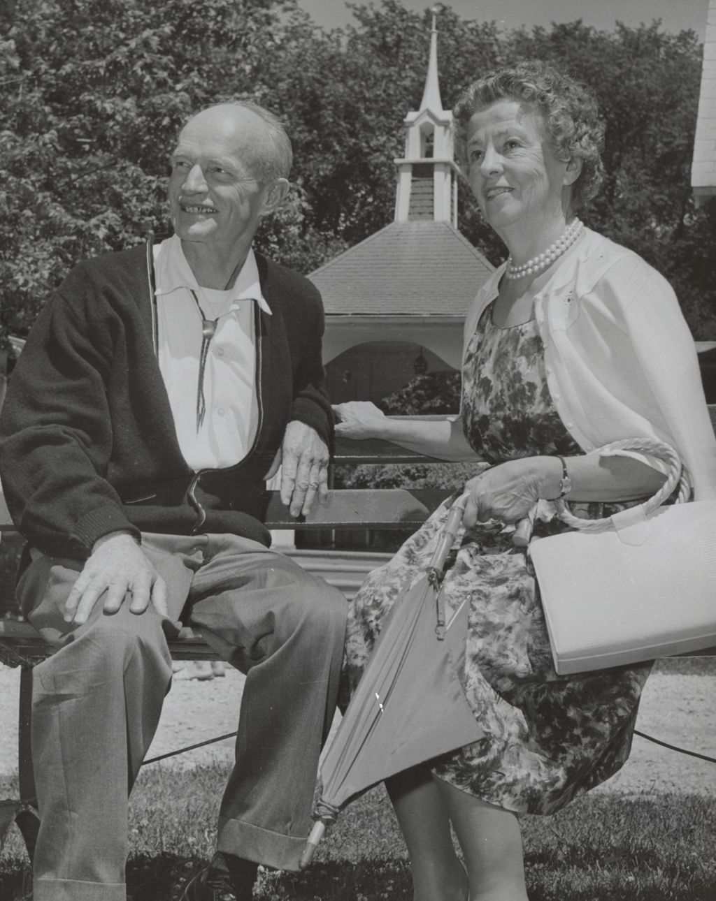 Robert Hicks, former co-director of Bowen Country Club, and Helen Bowen Blair sitting on a bench on the grass at Bowen Country Club 50th Anniversary celebration