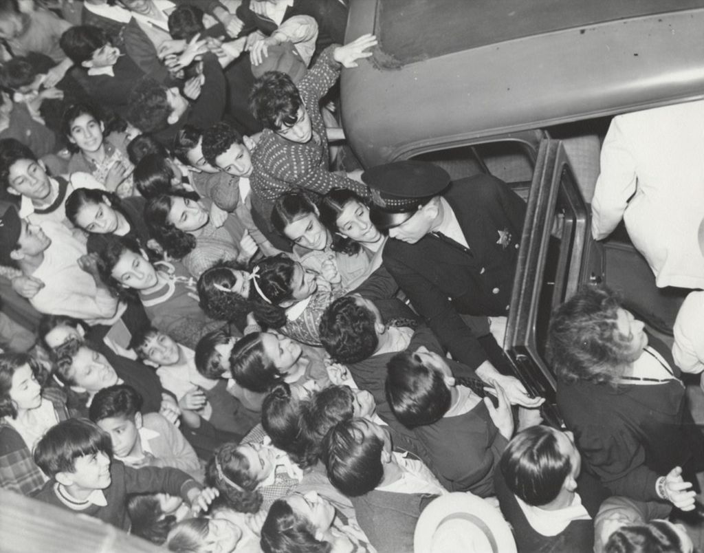 Large crowd gathers around car as Benny Goodman and band leave Hull-House after 1938 concert
