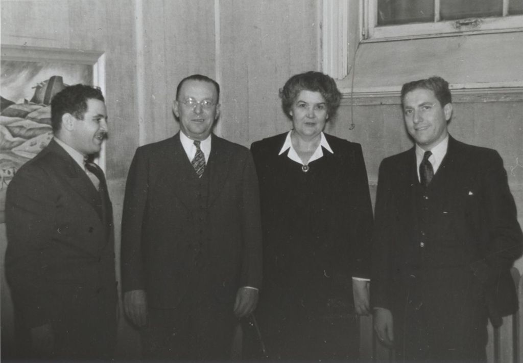 Miniature of Hull-House director Charlotte Carr standing with three men