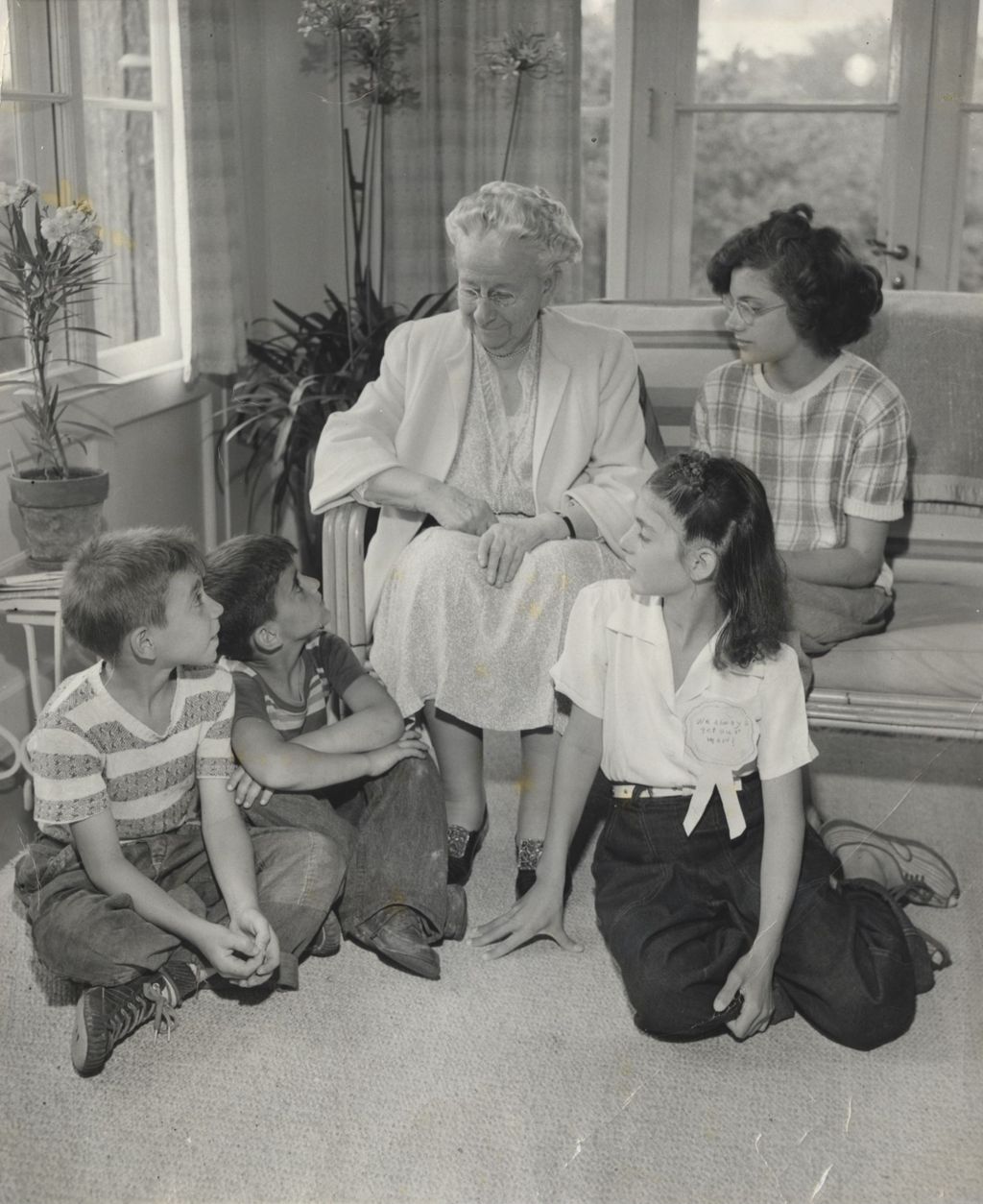 Louise de Koven Bowen sitting on a couch at Bowen Country Club alongside four children