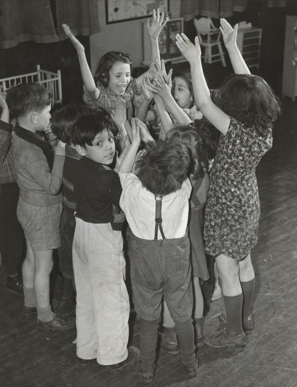 Children standing in a circle playing a game at Mary Crane Nursery