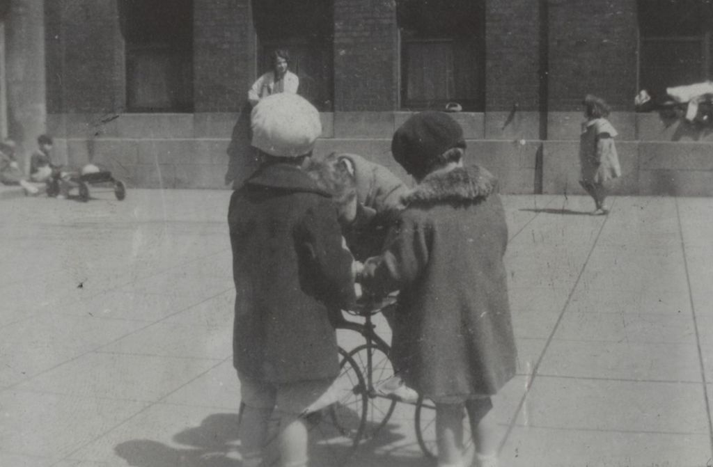 Miniature of Three children and a tricycle during recess at Mary Crane Nursery
