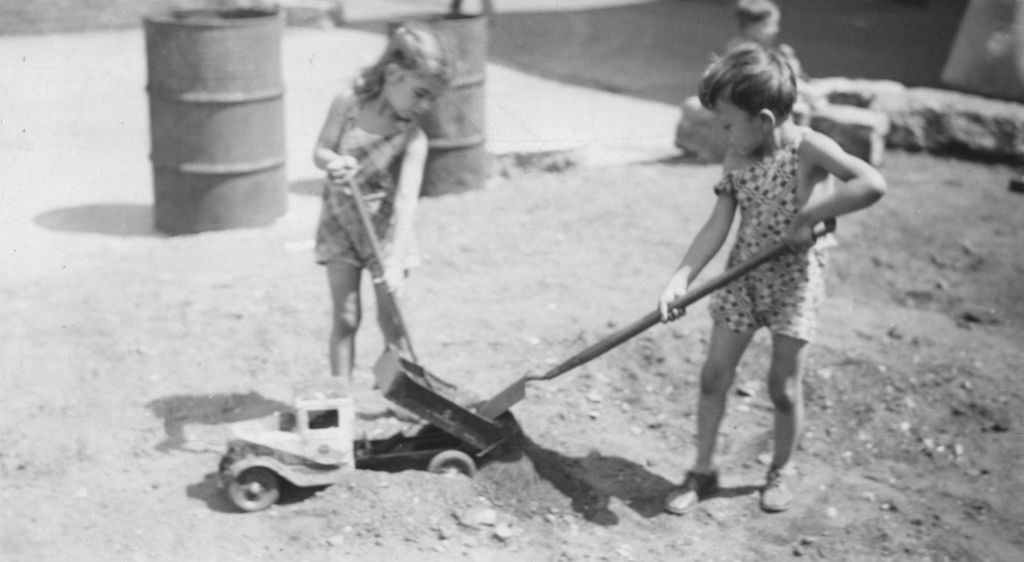Miniature of Two girls shoveling dirt into dump truck