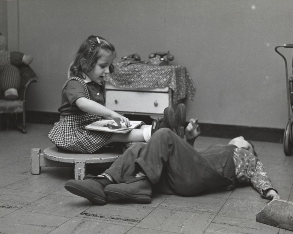 Miniature of Girl reading to boy at Mary Crane Nursery