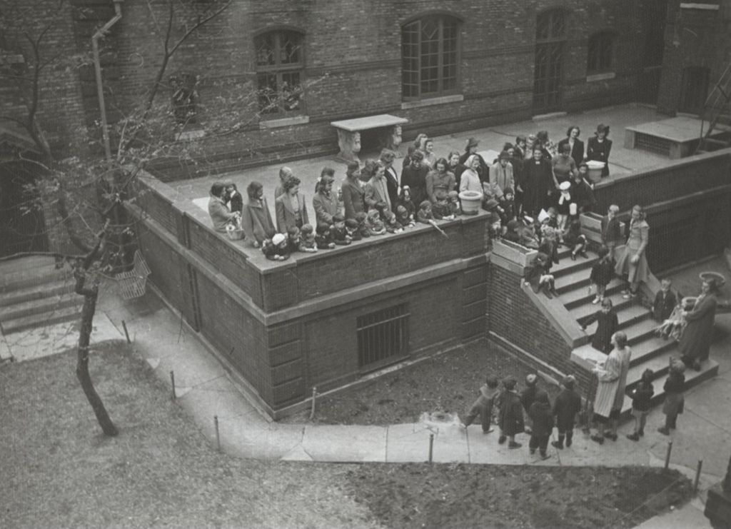 Women and children singing at a bulb-planting ceremony in Hull-House courtyard