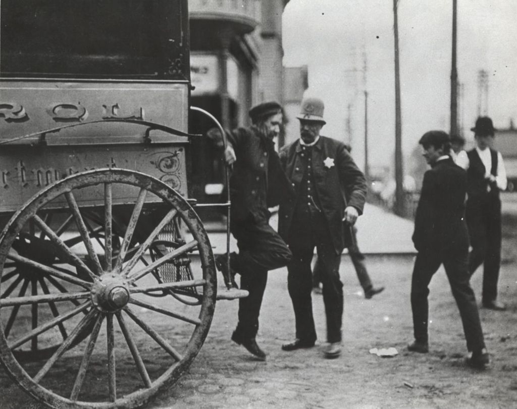 Miniature of Police officer talking to man at the back of a truck in a neighborhood near Hull-House