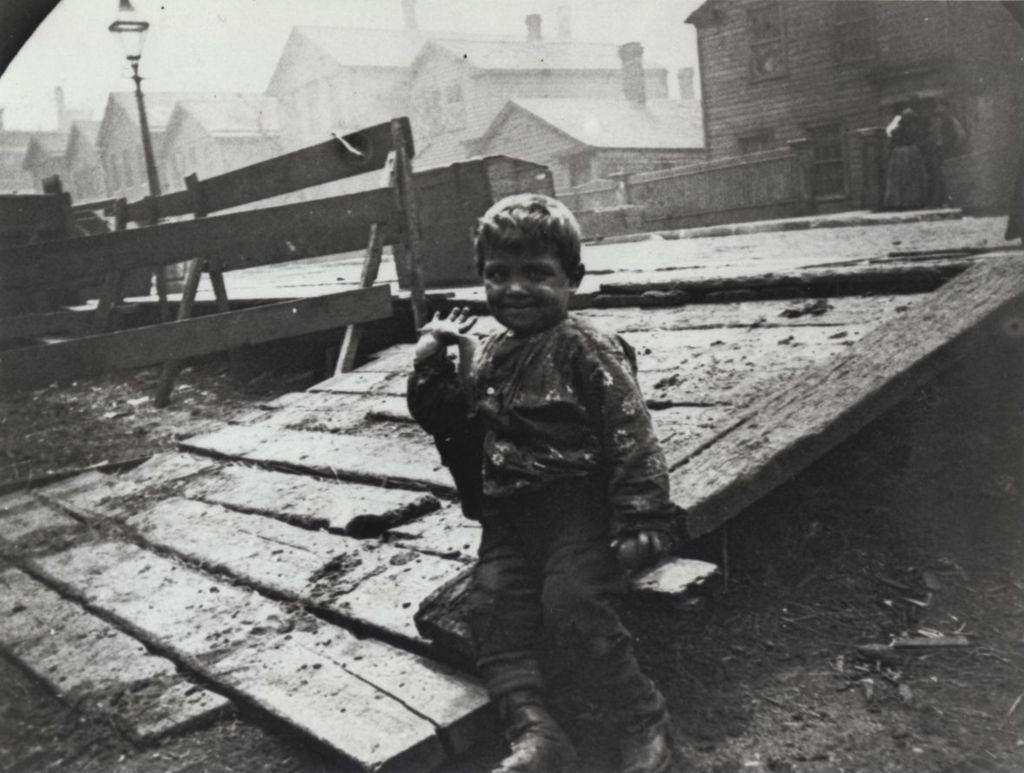 Miniature of Boy sitting on wooden ramp in neighborhood near Hull-House