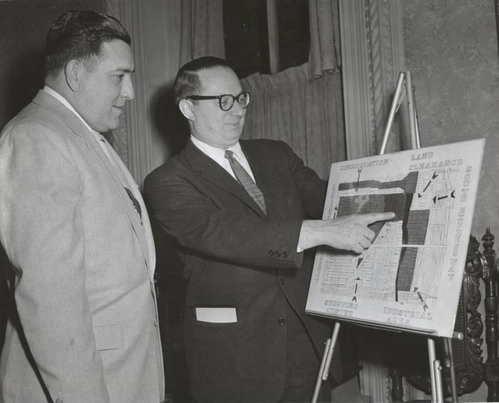 Anacleta Vara and Philip M. Hauser look at an urban renewal map of Chicago's Near West Side during a Hull-House Citizen Participation Dinner