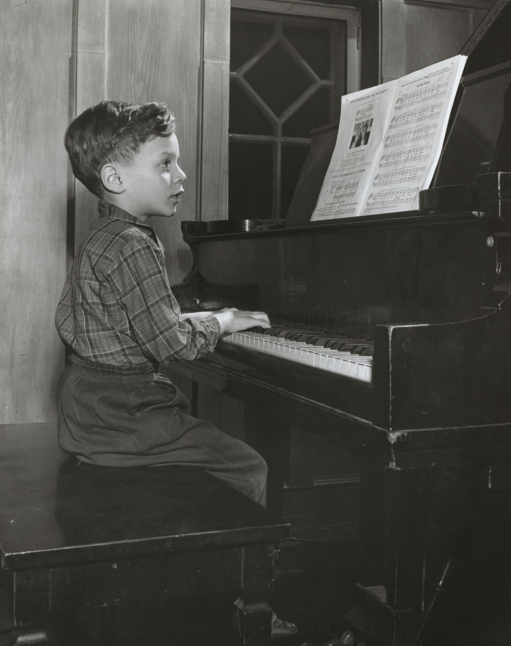 Boy playing piano at Hull-House Music School