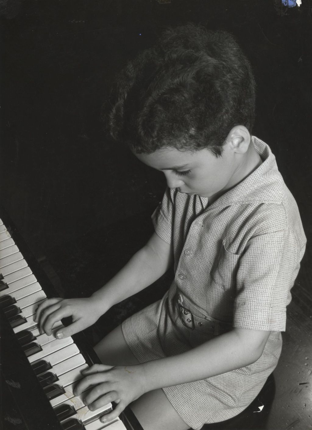 Young boy playing piano at Hull-House Music School