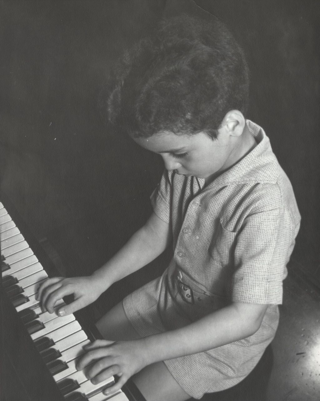 Young boy playing piano at Hull-House Music School