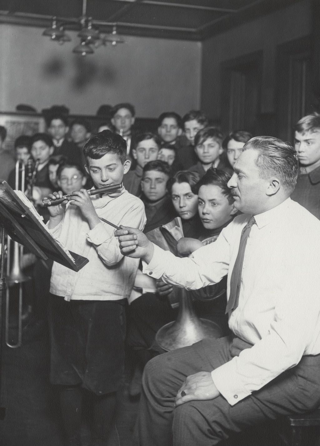 Miniature of James Sylvester instructs boy playing piccolo during Hull-House Boys' Club band class