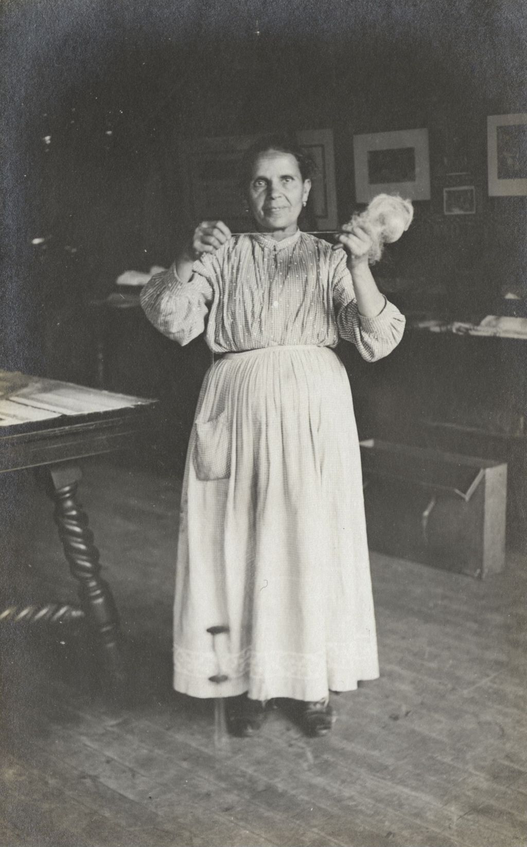 Postcard of woman holding partly spun yarn at Hull-House Labor Museum