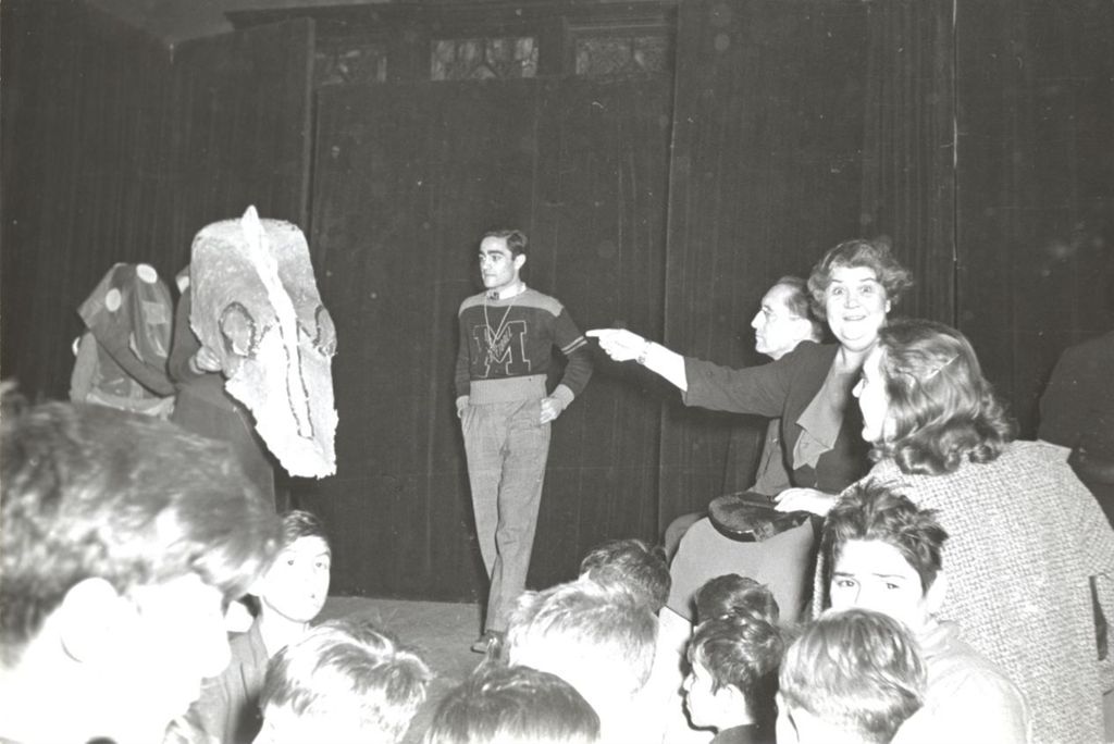 Children in a dragon costume on stage at Hull-House Halloween party