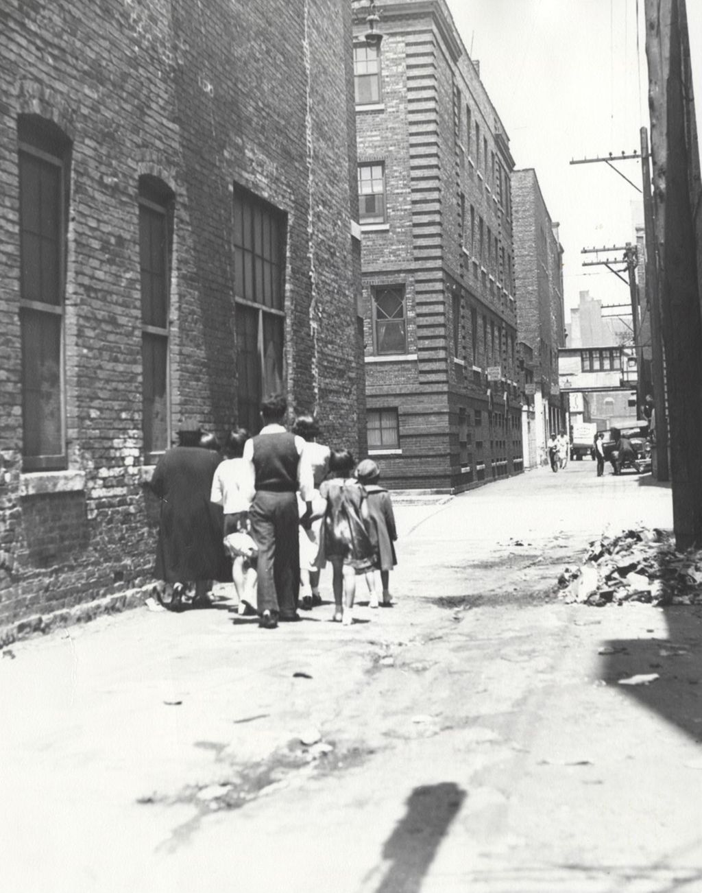 Miniature of Family of seven walking through alley toward Hull-House