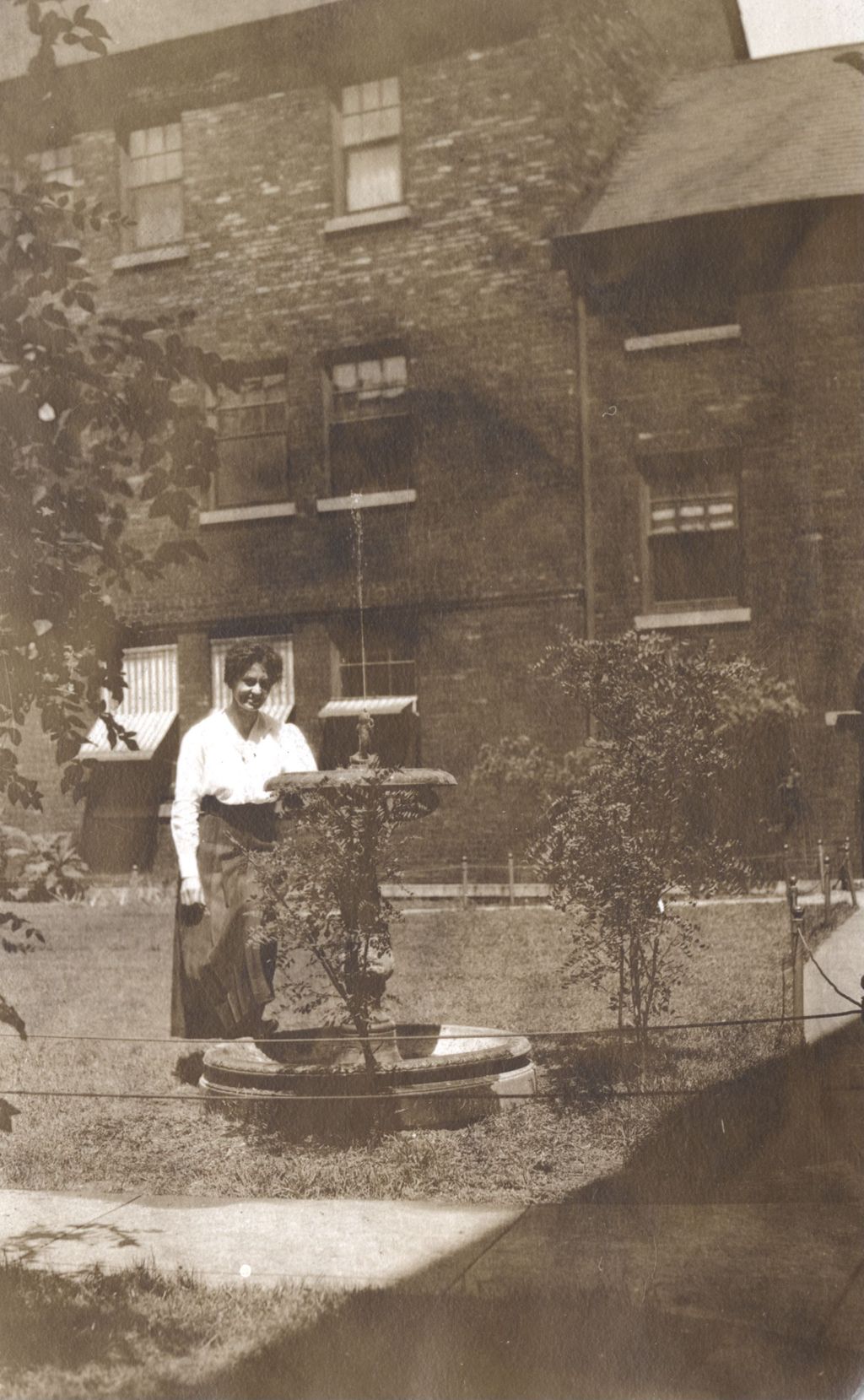 Miniature of Hull-House courtyard facing east with woman standing next to fountain
