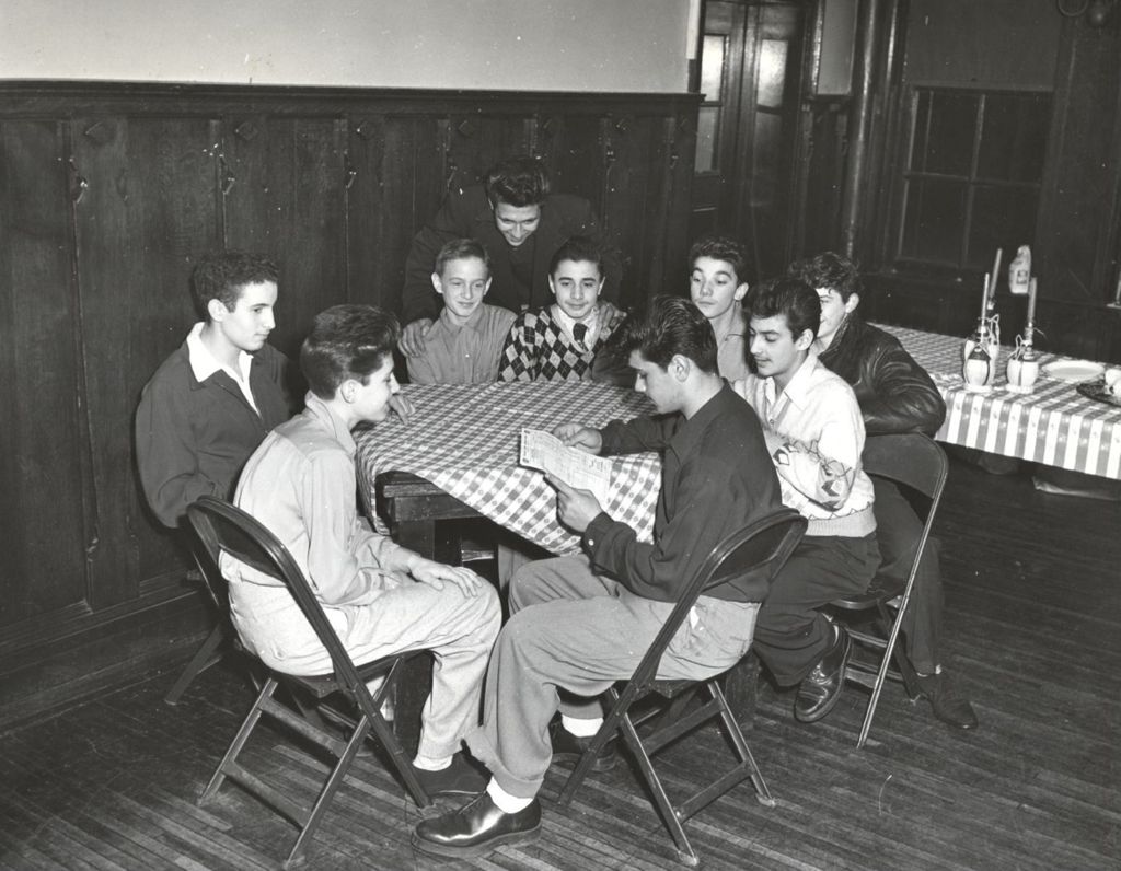 Young men sit around a table