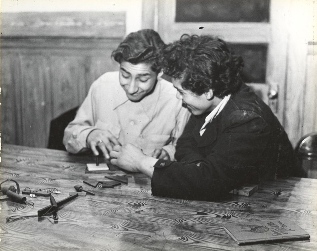 Two young men work on a puzzle