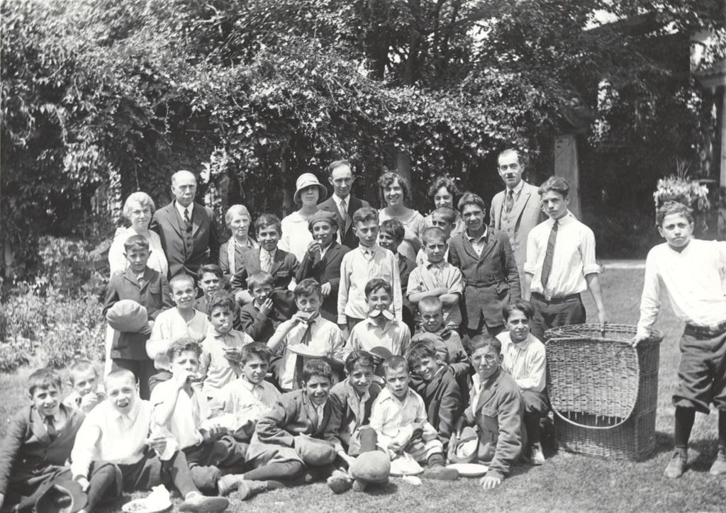 A large group of boys and adults pose for photo in the yard at Pick Estate