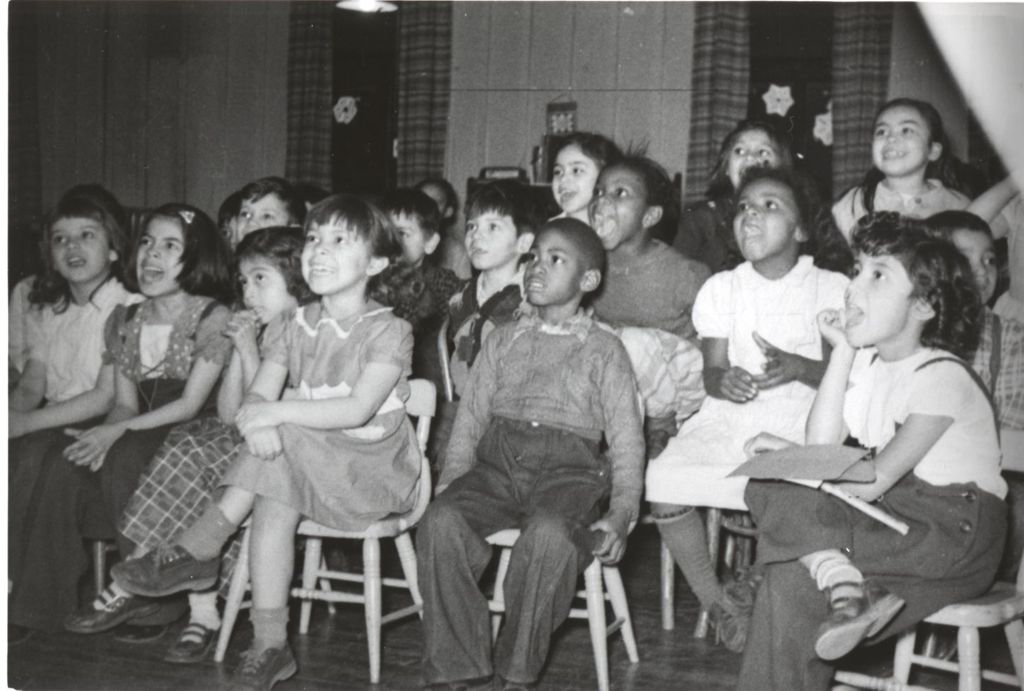 Children seated watching performance at Hull-House Christmas party