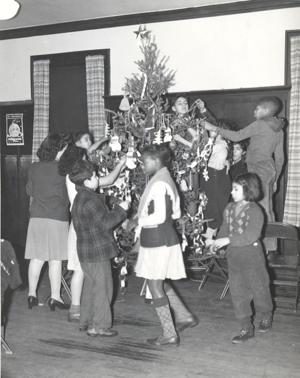 Woman and children decorate a Christmas tree