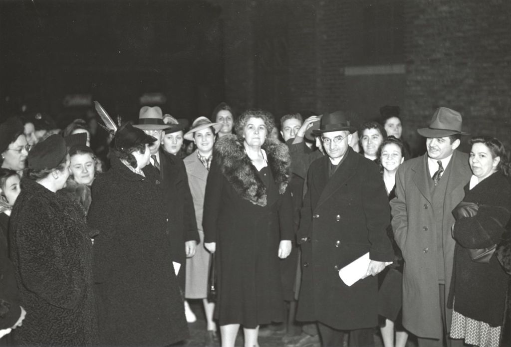 Charlotte Carr and priest with attendees at Hull-House Christmas event