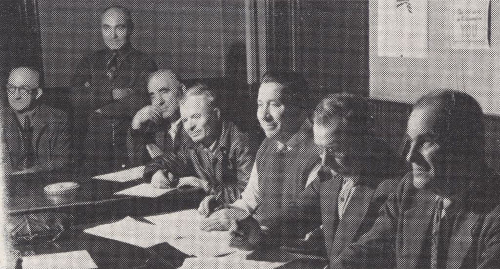 Seven men sitting at a table
